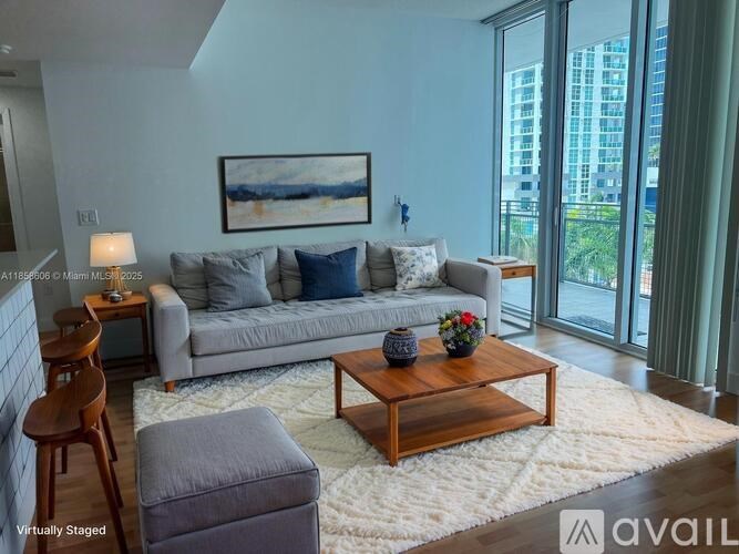 A living room with a grey couch, a wooden coffee table, and a painting on the wall.