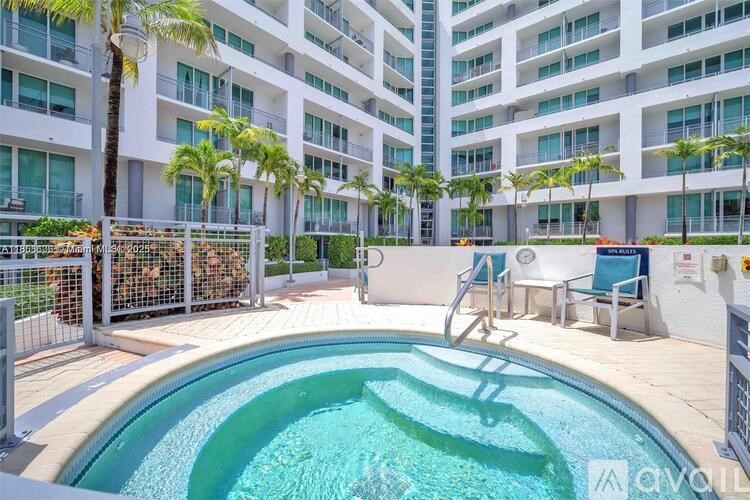 A small pool in a courtyard surrounded by a fence.