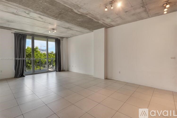 A spacious room with a large window and sliding glass doors.