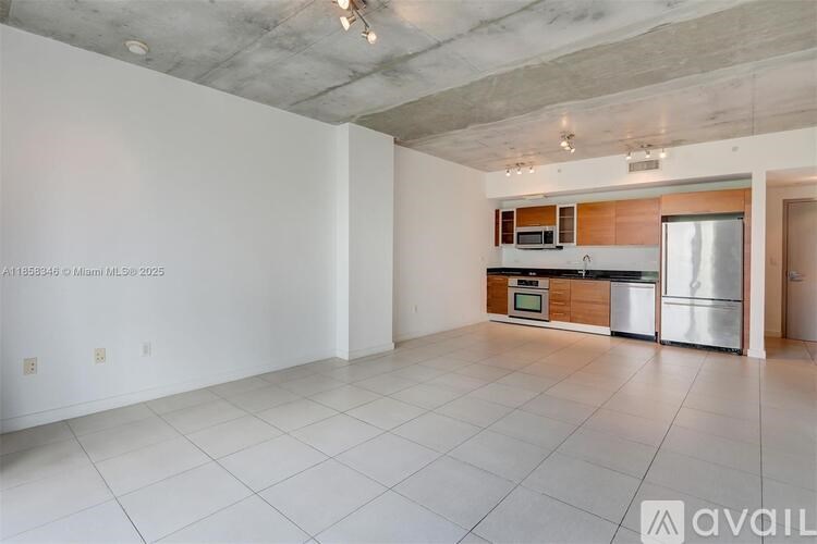 A spacious kitchen with white tiled floors and a modern design.