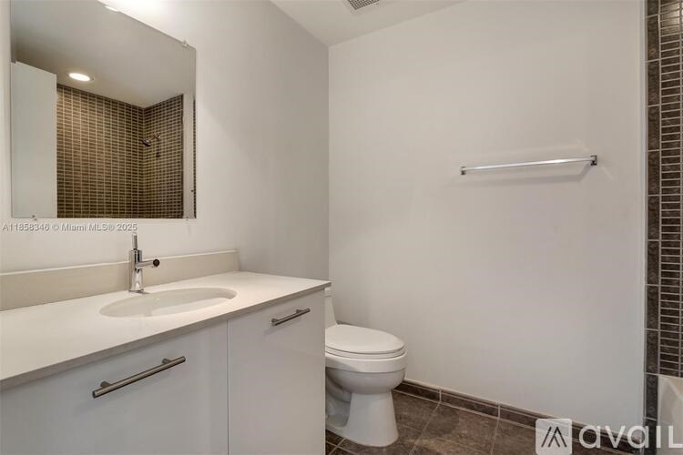 A white bathroom with a toilet, sink, and mirror.