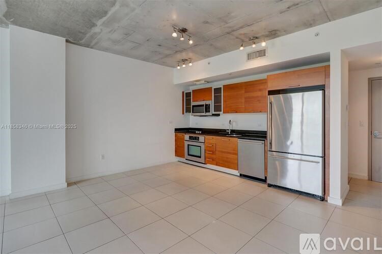 A kitchen with white tiled floors and a wooden backsplash.