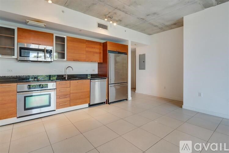 A kitchen with wooden cabinets and stainless steel appliances is available for rent.