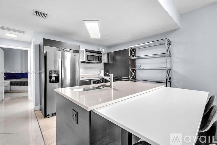 A modern kitchen with stainless steel appliances and a white countertop.