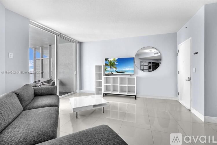 A living room with a grey sofa and a white coffee table.