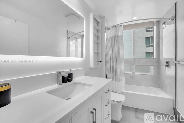 A white bathroom with a sink, toilet, and bathtub.