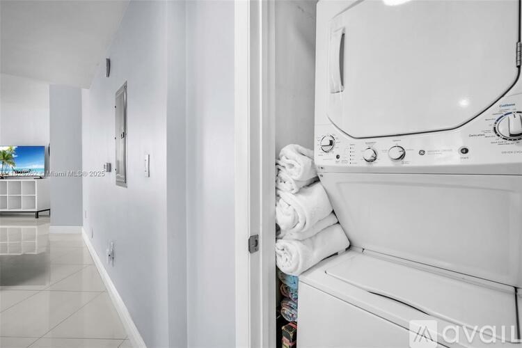 A white washing machine is in a room with white walls.
