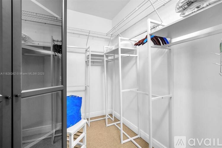 A room with white walls and a white bed frame with a blue blanket.