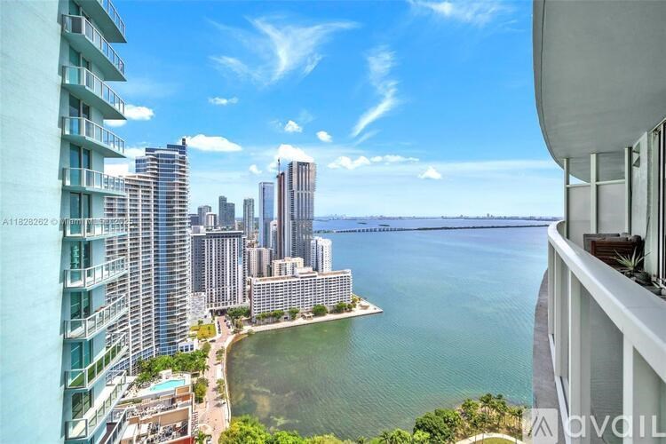 A view from a high-rise building overlooking a body of water with a city skyline in the distance.