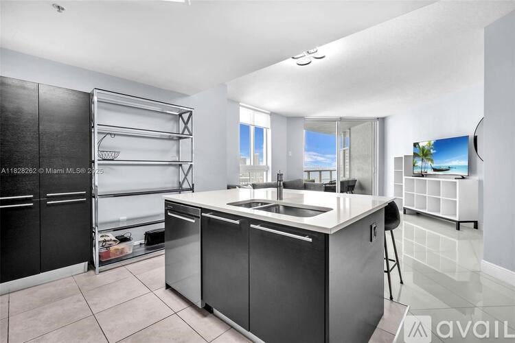 A modern kitchen with a large island and stainless steel appliances.