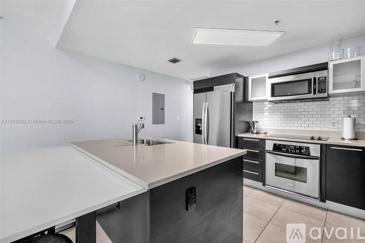 A modern kitchen with stainless steel appliances and a white island.