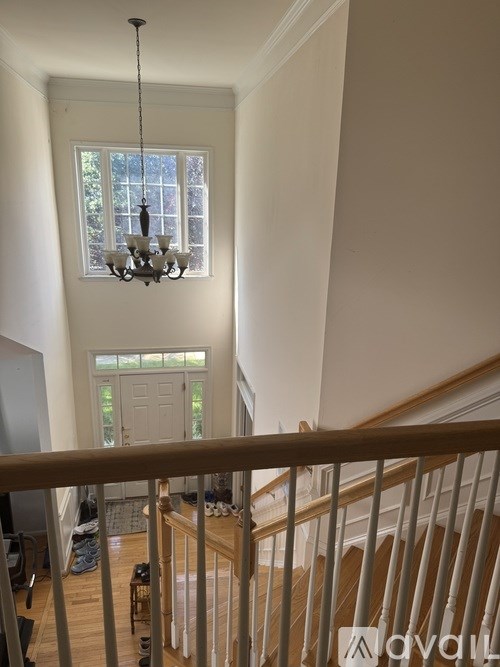 A chandelier hangs over a staircase in a home.