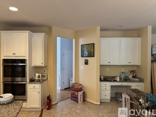 A kitchen with white cabinets and a countertop with a toaster and other items on it.