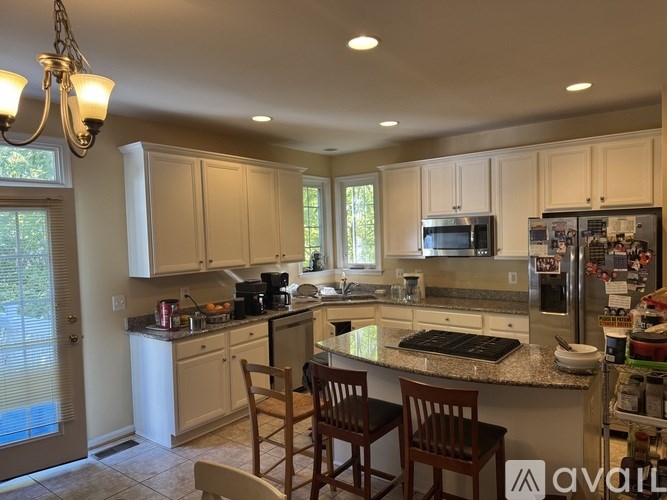 A kitchen with white cabinets and a granite countertop.