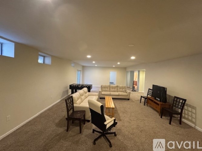A spacious kitchen with white cabinets and a dining table.
