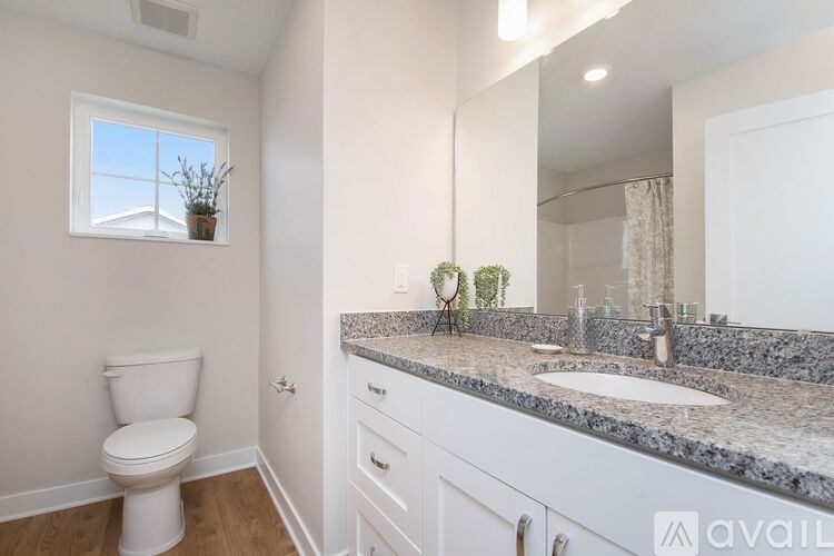 A bathroom with a white toilet and a granite countertop.