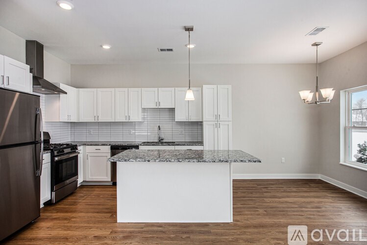 A kitchen with a granite countertop and white cabinets.