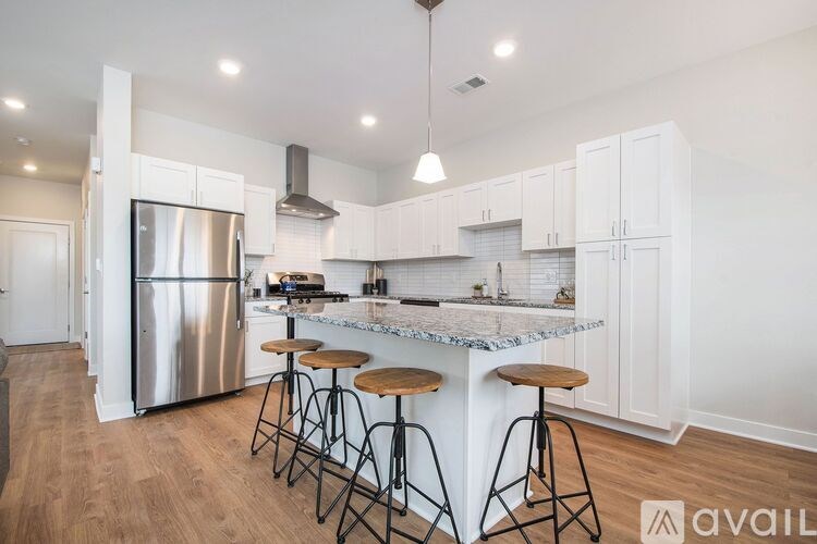 A kitchen with white cabinets and a marble countertop.