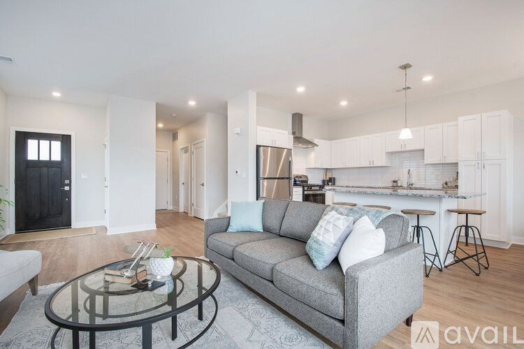 A modern living room with a grey couch and a glass coffee table.