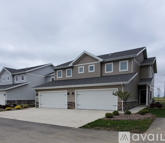 A modern house with a grey roof and two garages.