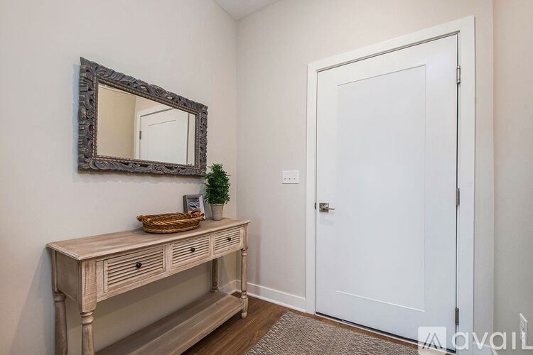 A white door is in a room with a mirror and a table.