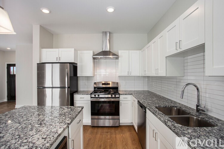 A modern kitchen with granite countertops and stainless steel appliances.