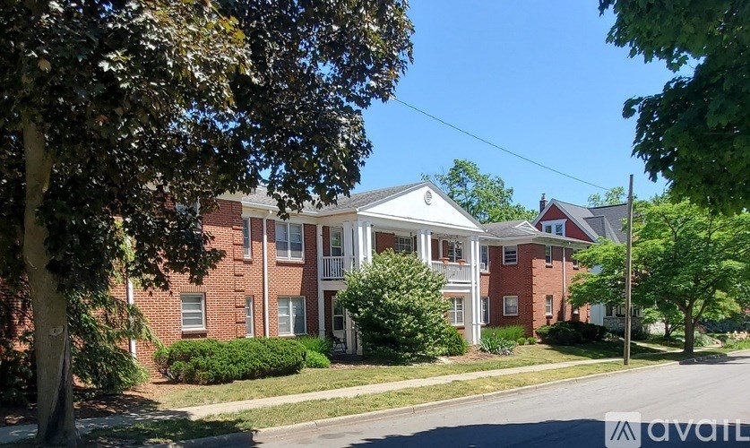 A large red brick house with a white porch.