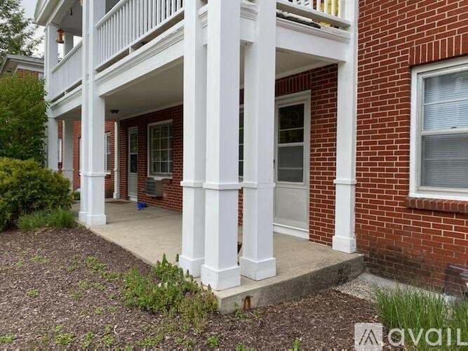 A red brick house with a white porch.