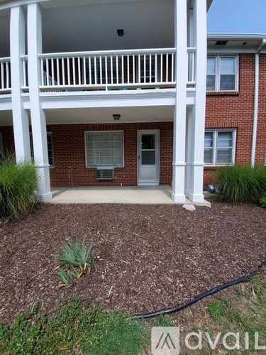 A house with a white porch and a brick exterior.