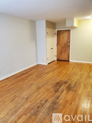 A room with wooden flooring and a door.