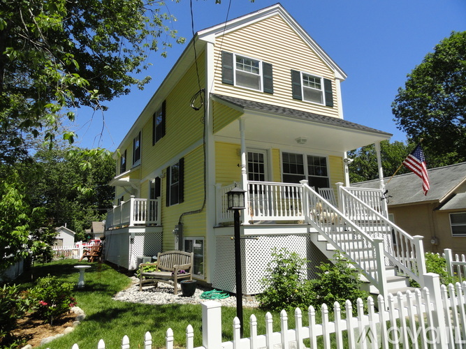 A yellow house with a white picket fence.