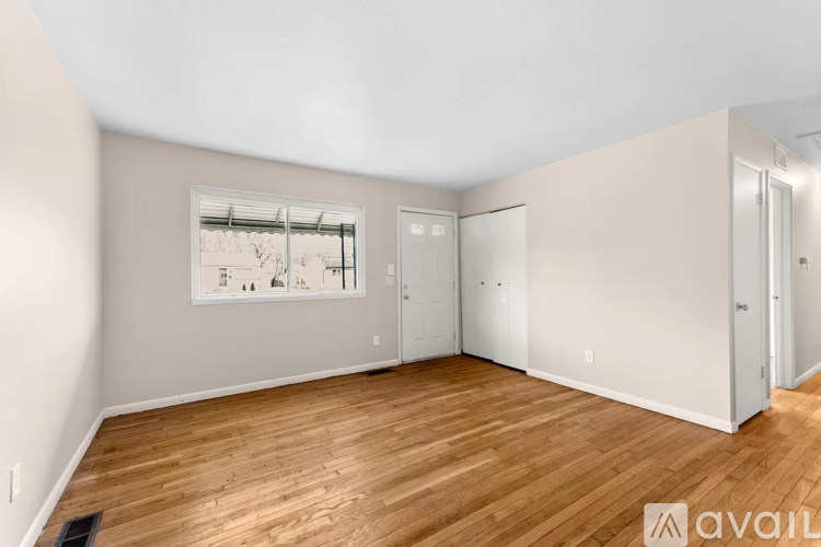 A room with wooden flooring and a framed picture on the wall.