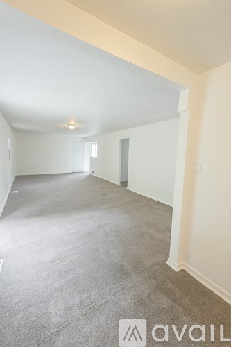 A spacious room with a carpeted floor and a white ceiling.