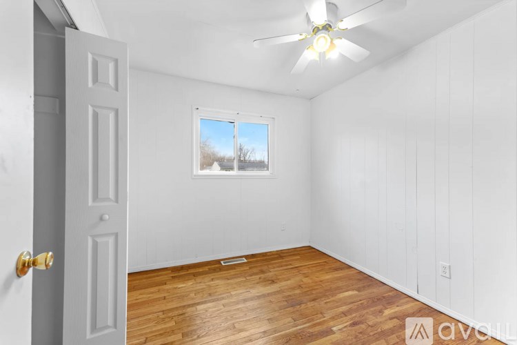 A room with a ceiling fan and a window showing a snowy landscape outside.