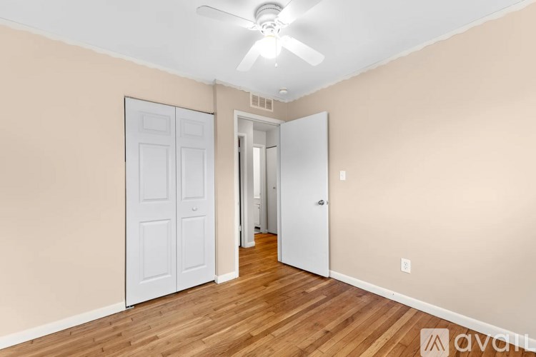 A room with a white ceiling fan and a white door.