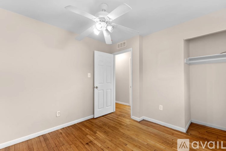 A room with a ceiling fan and a door.