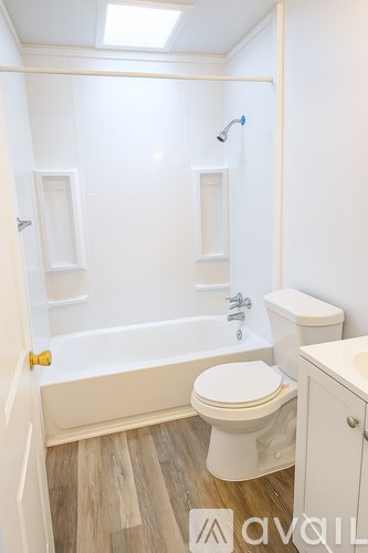A white bathroom with a toilet, sink, and bathtub.