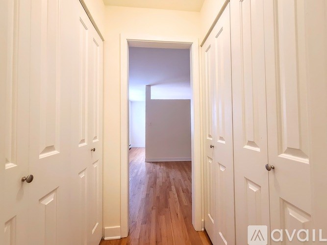 A hallway with white doors and wooden floors.