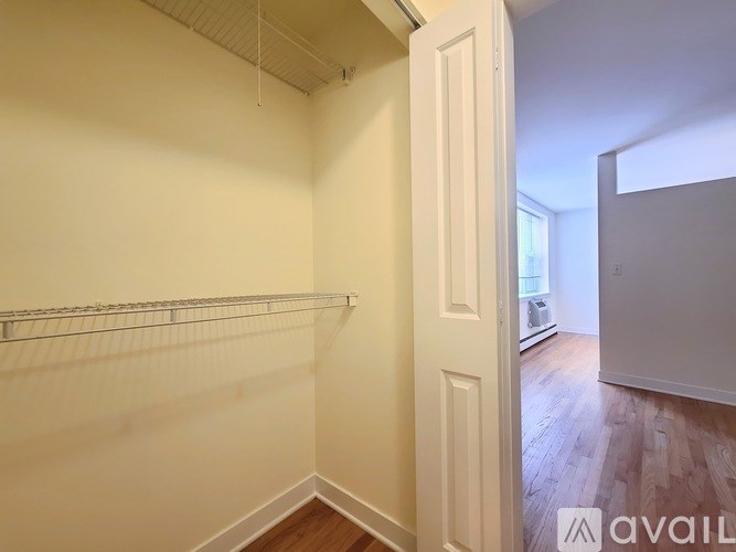Empty room with white walls and wooden floor.