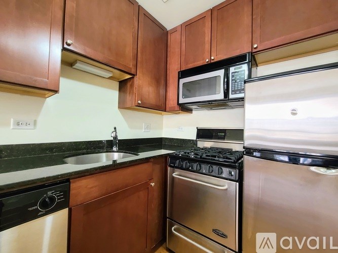 A kitchen with brown cabinets and black appliances.