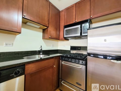A kitchen with brown cabinets and black appliances.