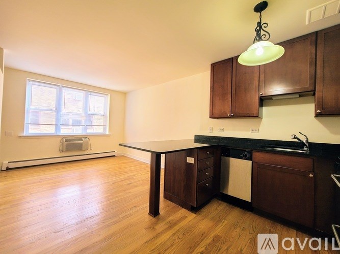 A kitchen with wooden floors and brown cabinets.
