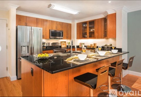 A kitchen with wooden cabinets and black countertops.