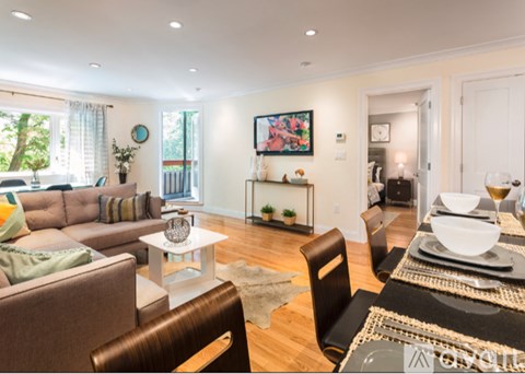 A modern living room with a brown couch, a white coffee table, and a rug.