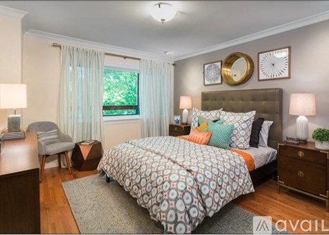 A bedroom with a large bed and a chair.