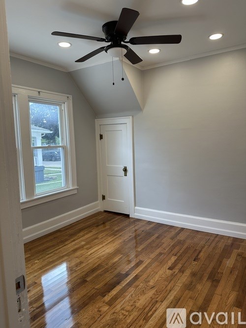 A room with a ceiling fan and wooden flooring.