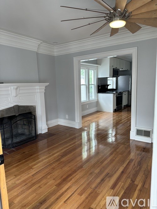 A room with a fireplace and a ceiling fan.