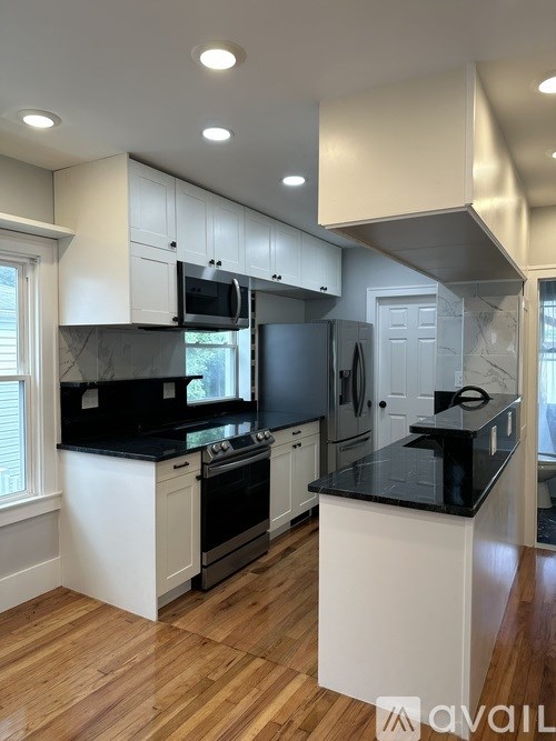A kitchen with black countertops and white cabinets.