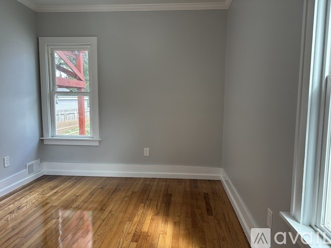 A room with wooden flooring and a window.