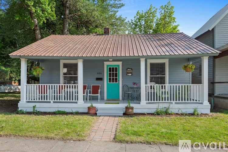 A small house with a porch and a green door.